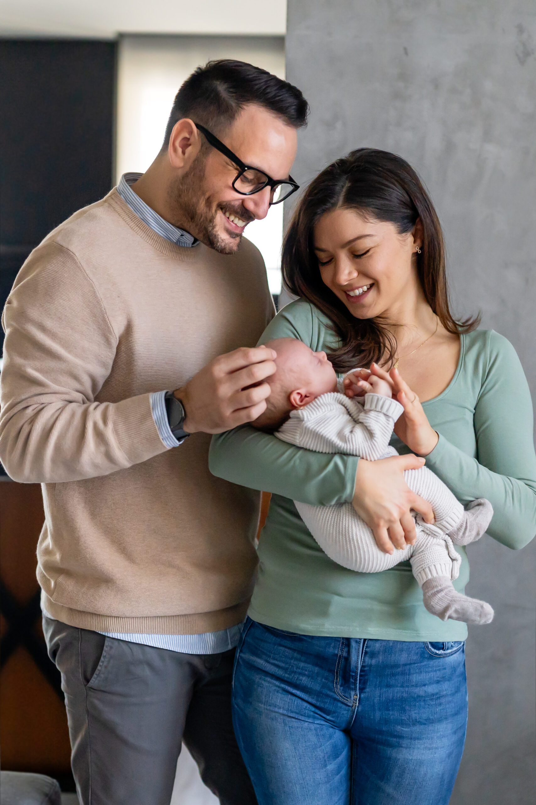 Family, adoption, baby, parenthood and people concept. Happy mother father with newborn baby at home