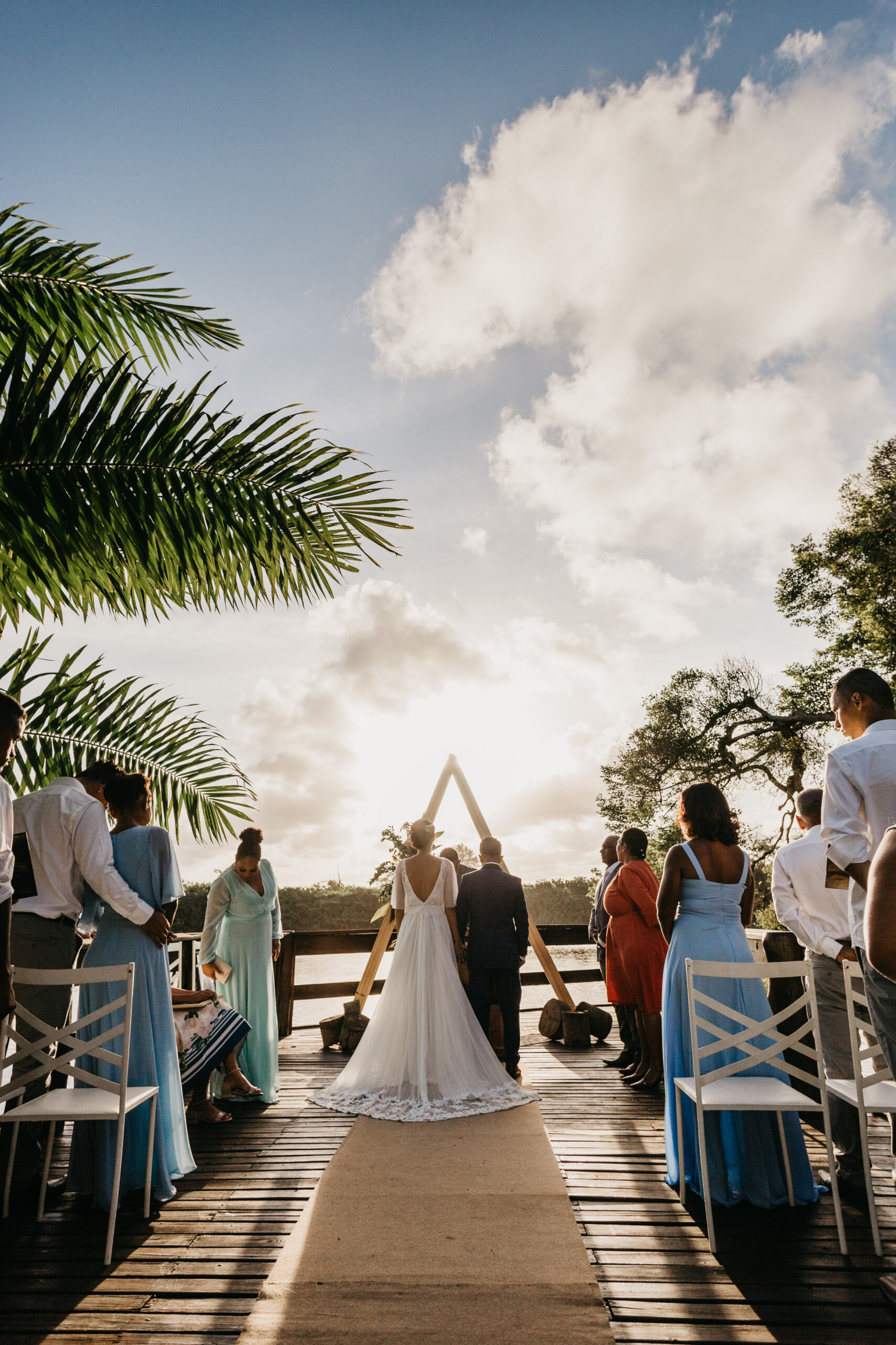 Vertical shot of an outdoor wedding altar with the bride and groom with guests under the sky